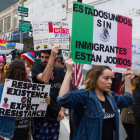 Manifestantes sostienen pancartas durante una protesta en Los Ángeles por el aumento de las redadas y las políticas antiinmigrantes.