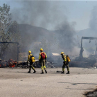 Los brigadistas ante dos cajas de camiones calcinadas. BARREDO