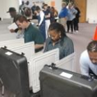 Varios ciudadanos estadounidenses depositan sus votos en las cabinas preparadas para ello