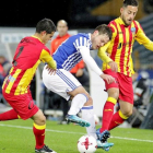 Bautista, de la Real, pelea un balón entre dos jugadores del Lleida.