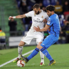 Karim Benzema lucha por el balón con el uruguayo Leandro Cabrera en un lance del partido entre el Getafe y el Real Madrid. JUANJO MARTÍN