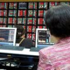 Una inversora comprueba los paneles en la Bolsa de Taipei, en Taiwan