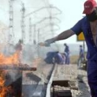 Un trabajador de Izar prepara una barricada como símbolo de protesta