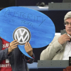 Una europarlamentaria alemana muestra un cartel en el que se lee "La austeridad es tóxica" y un logopito de la compañía Volkswagen durante la intervención de Angel Merkel en el Parlamento Europeo, ayer