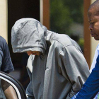 Oscar Pistorius es escoltado por varios policías tras ser detenido en su casa de Pretoria, este jueves.