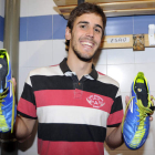 El futbolista de la Cultural Esaú García muestra las botas que utiliza cada domingo con las dos medallas de la Virgen del Camino pegadas debajo de la plantilla.