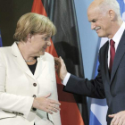 Angela Merkel saluda al primer ministro griego George Papandreu, ayer en Berlín.