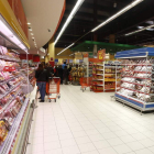 Varias personas realizan la compra en un supermercado.