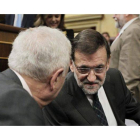 El presidente del Gobierno, Mariano Rajoy (d), conversa con el ministro de Asuntos Exteriores y de Cooperación, José Manuel García-Margallo (i), al inicio de la sesión de control al Gobierno.