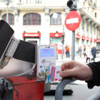 Un usuario paga con una tarjeta electrónica en un autobús de León.