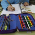 Un niño realiza los deberes delante de uno de sus libros.