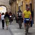 Dos peregrinos en bicicleta, atravesando la calle del Reloj de Ponferrada, el pasado miércoles