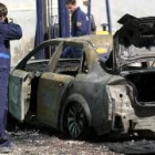 Un policía hace fotos del coche, que quedó totalmente calcinado