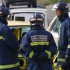 Tres agentes del Cuerpo de Bomberos de Ponferrada permanecen junto a un coche siniestrado