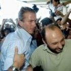 El jugador David Beckham es empujado por fotógrafos y fans en la despedida del Madrid en Barajas