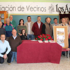 Organización y vecinos posan junto al cartel ganador y al del segundo clasificado, Ramón Celada.