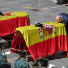 El ministro del Interior besa en la plaza de la Catedral de León la Cruz al Mérito de la Guardia Civil con distintivo rojo colocada sobre uno de los féretros cubierto con la bandera de España