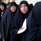Hombres y mujeres guardan cola por separado para votar en un colegio electoral de Bagdad