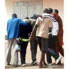 Un grupo de inmigrantes repatriados se abraza al llegar a Dakar
