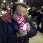 Un fumador enciende un cigarrillo en la calle