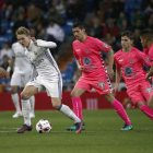 El centrocampista noruego del Real Madrid Martin Odegaard, defiende el balón entre varios jugadores de la Cultural.