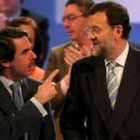 José María Aznar conversa con Mariano Rajoy durante la convención del PP que concluyó ayer en Madrid