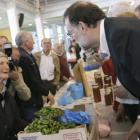 El líder del PP, Mariano Rajoy, charla con una dependienta durante un paseo electoral por Galicia.