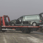 La grúa retira el coche fúnebre, que transportaba un cadáver en su interior.