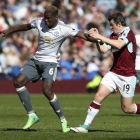 Joey Barton, a la derecha, peleando por un balón con Paul Pogba, del Manchester United.