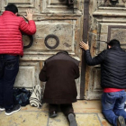 Peregrinos rezan en al puerta del Santo Sepulcro, cerrado.