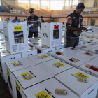 Empleados electorales ponen a punto las urnas antes de distribuirlas en las mesas electorales.