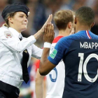 Una miembro de la banda Pussy Riot chocandole la mano a Kylian Mbappé.