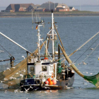 Un barco recoge sus redes tras la jornada de pesca.
