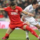 El centrocampista alemán del Madrid, Mesut Özil, luchando con Cáceres.