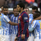 Los jugadores del Málaga celebran en gol de Juamni ante el gesto contrariado de Luis Suárez.