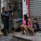 Una mujer y un niño contemplan la operación en la favela. ANDRÉ COELHO