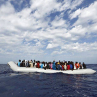 Refugiados a borde de un cayuco frente a la costa de Lampedusa, en Italia.