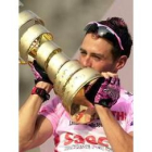 Gilberto Simoni besa el trofeo que le acredita como vencedor del Giro