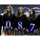 Los niños del Colegio San Ildefonso de Madrid posan con el número ganador del primer premio del sorteo del Niño.