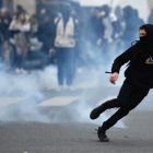 Un manifestante huye de los gases disparados por la policía.