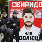 Varias personas pasan junto a un póster electoral del partido nacionalista Rodina (Patria), en Moscú, este jueves.