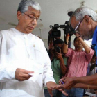 Manik Sarkar (izquierda), jefe de Gobierno de Tripura, se dispone a votar en Agartala, capital del estado, este lunes.