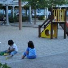 Dos pequeños juegan en el parque de la plaza de los Reyes Católicos