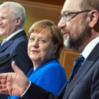 Schulz, en primer plano, seguido de Merkel, tras alcanzar el acuerdo esta mañana