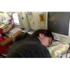 Fotografía de archivo de un jóven dormido ante un ordenador.