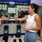 La lotera Esther Gloria Almeida (izquierda) invita a cava a sus clientes, este sábado.