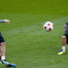 Messi observa a Milito golpeando el balón, durante un entrenamiento en el 2011.