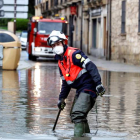 Un bombero achica agua en una calle de Salamanca anegada por la tromba. J.M. GARCÍA