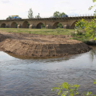 Una isleta de tierra junto al puente marca el comienzo de las obras de la pasarela.