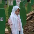 Una niña observa las tumbas de más de seiscientos musulmanes bosnios en los funerales de ayer